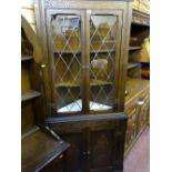 Standing corner cupboard with upper twin glazed doors over base carved doors