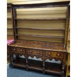 A Victorian oak Welsh dresser having a planked platform base, three drawers and an open rack with