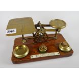 A lovely vintage set of postal scales on a wooden stand with weights and mounted instructions for