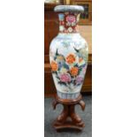 A twentieth century floor standing Oriental baluster vase on a decorative wooden stand, 135cms