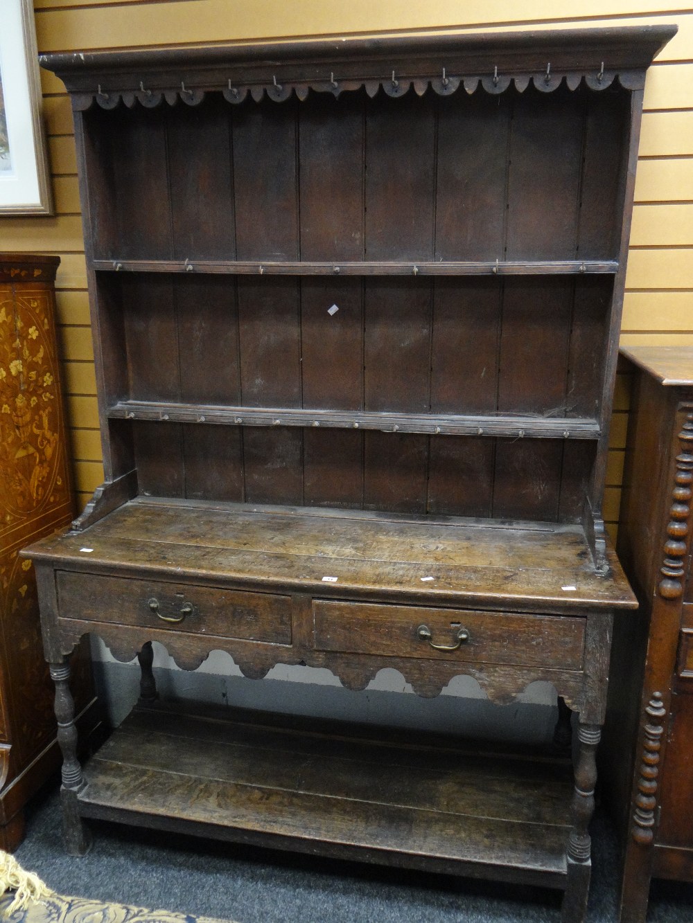 Antique oak narrow dresser having boarded rack back above two-drawer pot-board base raised on