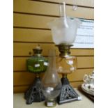 Two vintage glass reservoir oil lamps on metal bases Condition reports provided on request by