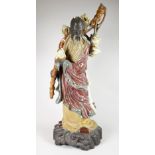 A Lladro pottery model of a Chinese scholar with pomegranates on a naturalistic base, 52cms high