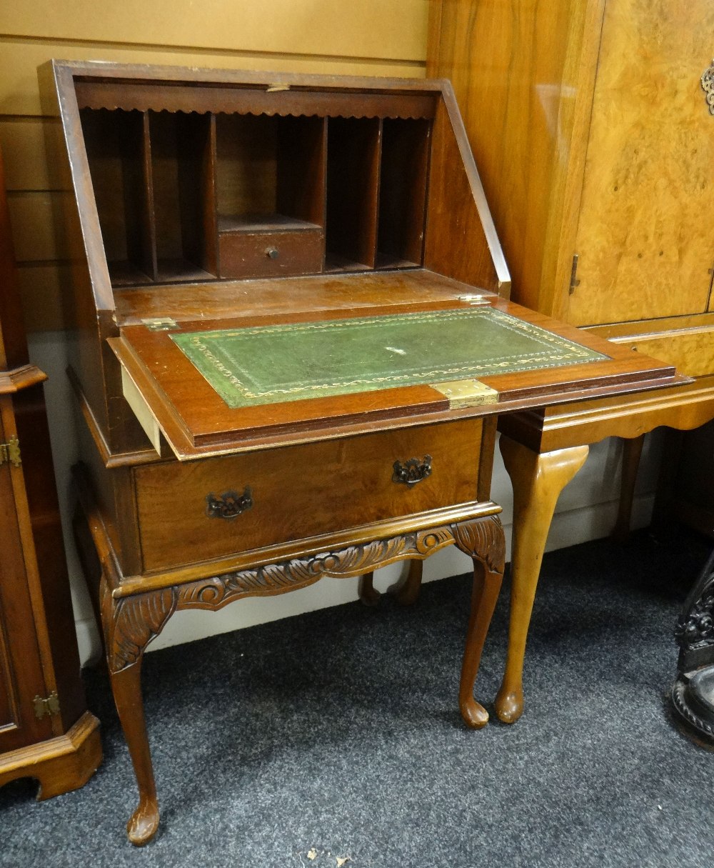 An antique reproduction burr wood sloped compact bureau with two drawers and carved base, 53cms wide