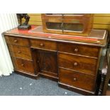 A Victorian mahogany desk of shallow proportions and having centre cupboard flanked by three