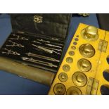 A fitted wooden boxed set of vintage laboratory brass weights, bearing label to the box for