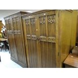 A pair of matching carved panelled wardrobes and a matching dressing table with three centre drawers