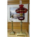 Two oil lamps - one with Corinthian Romanesque column base on a rectangular stand with ruby glass