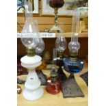 A group of five oil lamps including cranberry glass and three with metal bases Condition reports