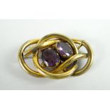 A believed gold knot brooch set with two faceted oval amethysts Condition reports provided on