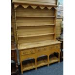 A pine dresser with platform base having three drawers and three shelf open rack, 136cms wide