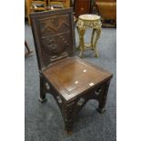 Oak shield back hall chair having Gothic designs, the shield depicting lions, axes and arrows, 89cms