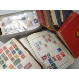 A white cardboard carton containing various albums of stamps including 'The Diplomat' red album with