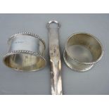 Pair of silver napkin rings and a white metal meat skewer