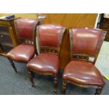 Set of three leather upholstered scroll back chairs
