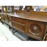 A vintage oak railback sideboard with two centre drawers and the flanking cupboards having lion head