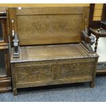 A good vintage carved oak monk's bench with box seat and carved lion-form arms, 105cms wide