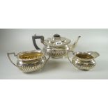 A three-piece oval based silver teaset of teapot, cream jug and twin-handled sugar basin of fluted