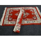 Pair of red ground Chinese-style wash rugs (2)