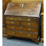 An antique oak bureau with sloped front and chest base of two long, two short and upper shallow