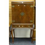 A good reproduction burr walnut standing cocktail cabinet with base drawer and brass mounts over