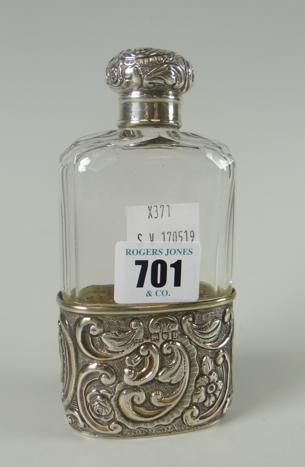 A Victorian silver mounted faceted glass hip flask with raised foliate decoration and cartouche,