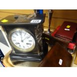 A black marble mantel clock with circular Roman numeral face, pair of EPNS candlesticks, wallets