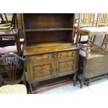 A vintage stained oak dresser having a cupboard base and open shelf top, 101cms wide