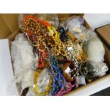 A CARDBOARD BOX CONTAINING A LARGE QUANTITY OF MIXED COSTUME JEWELLERY AND BEADS etc.