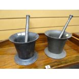TWO SIMILAR CAST IRON CYLINDRICAL PESTLE AND MORTAR SETS (2)