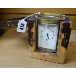 CARRIAGE CLOCK in brass and of oval shape raised on four feet with French movement, the dial