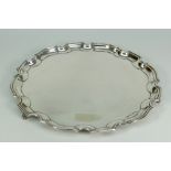 GEORGE V SILVER SALVER having pie crust edge raised on three scroll-type feet, Birmingham 1932,