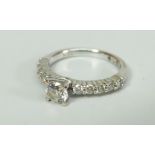 18K WHITE GOLD DIAMOND RING, the central round brilliant stone flanked by ten further diamonds. 3.