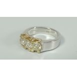 18CT WHITE GOLD THREE STONE YELLOW DIAMOND RING, having further diamond chips to setting. Total