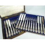 CASED TWELVE-PIECE DESSERT KNIFE & FORK SET having silver handles with scroll and shell