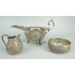 THREE PIECES OF BELIEVED INDIAN SILVER comprising scroll-handled sauce boat decorated with deities