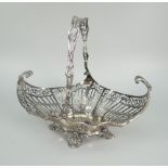 EDWARD VII SILVER PIERCED SWING-HANDLED BASKET of scroll decoration raised on four scroll feet,