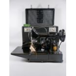 A SINGER 222K SEWING MACHINE with original foot pedal, rubber mat, accessories and booklets, in