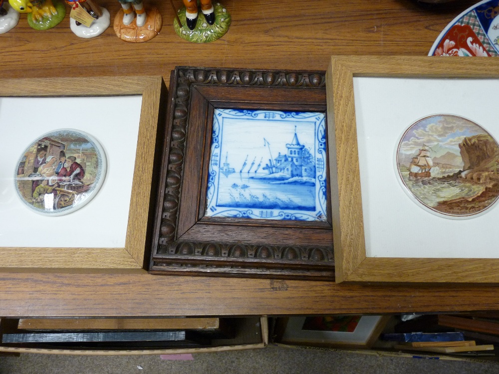 Two framed Prattware pot lids and two Dutch painted blue and white tiles in oak frames with egg