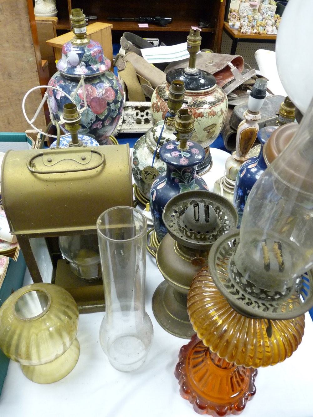 Three vintage oil lamps, a brass paraffin lamp and a collection of modern Oriental pottery table