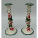 A PAIR OF LLANELLY CANDLESTICK HOLDERS with circular bases and decorated with tea-roses,