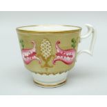 A SWANSEA CUP decorated with pink flowers and gilded finials in a brown reserve (no saucer)