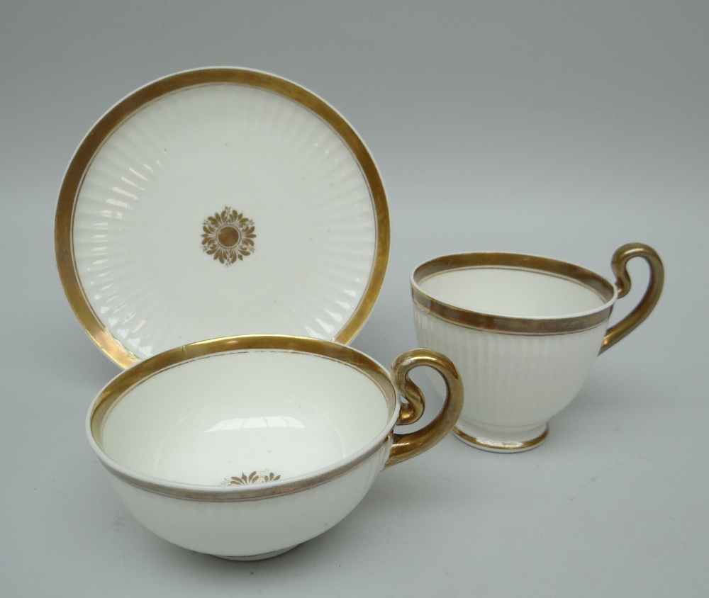 A SWANSEA PORCELAIN PARIS FLUTE TRIO with gilding and centred floral motif, stencilled SWANSEA