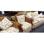 A THREE PIECE BERGERE SUITE comprising three seater sofa and a pair of armchairs and having later