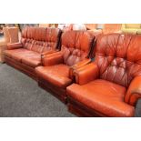 A C20TH LEATHER THREE PIECE SUITE in red buttoned upholstery comprising three-seater settee and pair