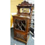 A CARVED MIRROR BACK EDWARDIAN MAHOGANY MUSIC CABINET with four front base and upper glazed door,