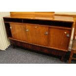 A MID-CENTURY DANISH-STYLE SIDEBOARD raised on square supports, with three sliding doors and full