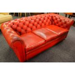 A THREE SEATER CHESTERFIELD TYPE SETTEE in red leather