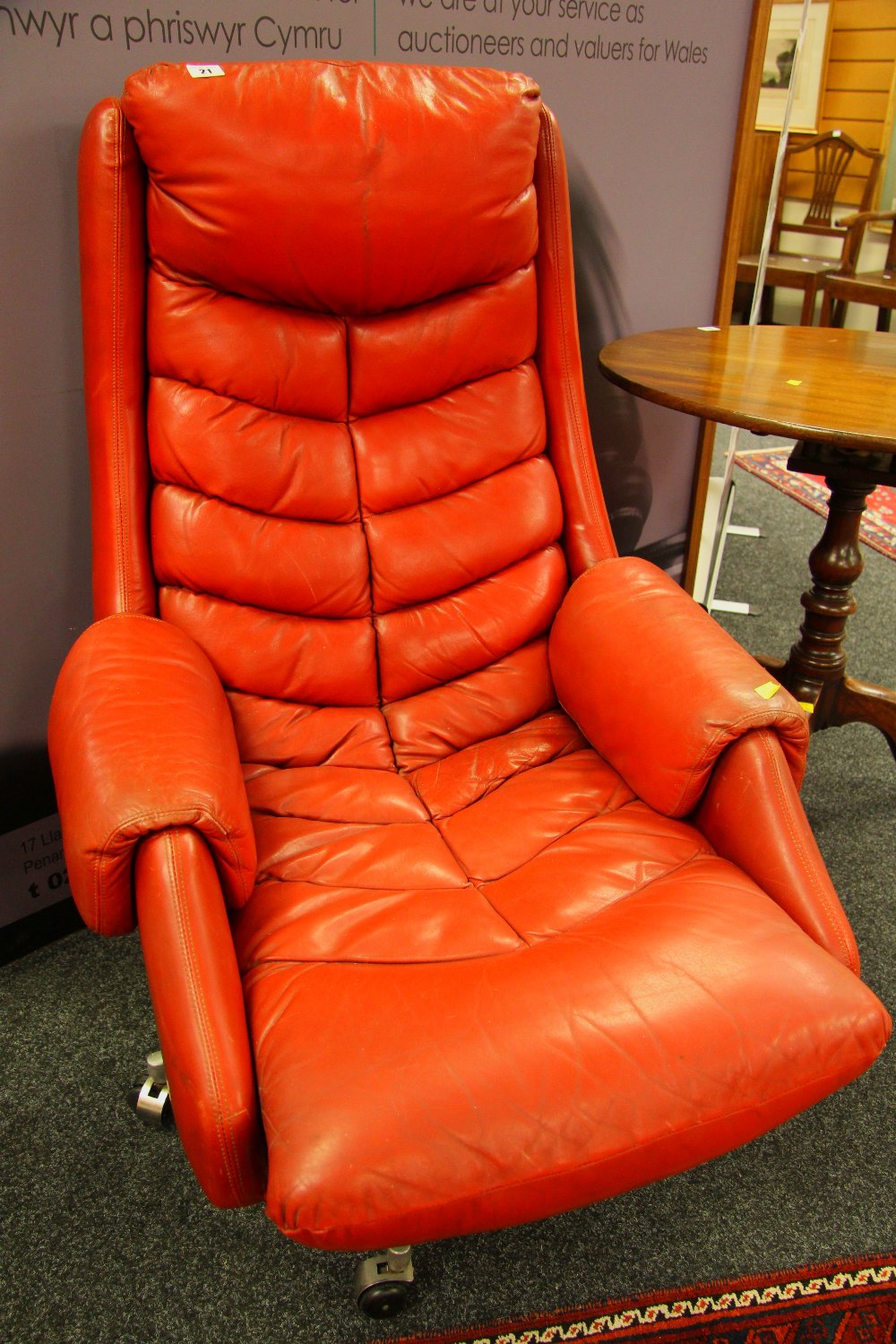 A MID-CENTURY NORWEGIAN LEATHER ARMCHAIR having swivel action over a chrome spoked base with castors