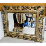 A LARGE BEVELLED WALL MIRROR in a painted scrolling and leaf form open-carved frame